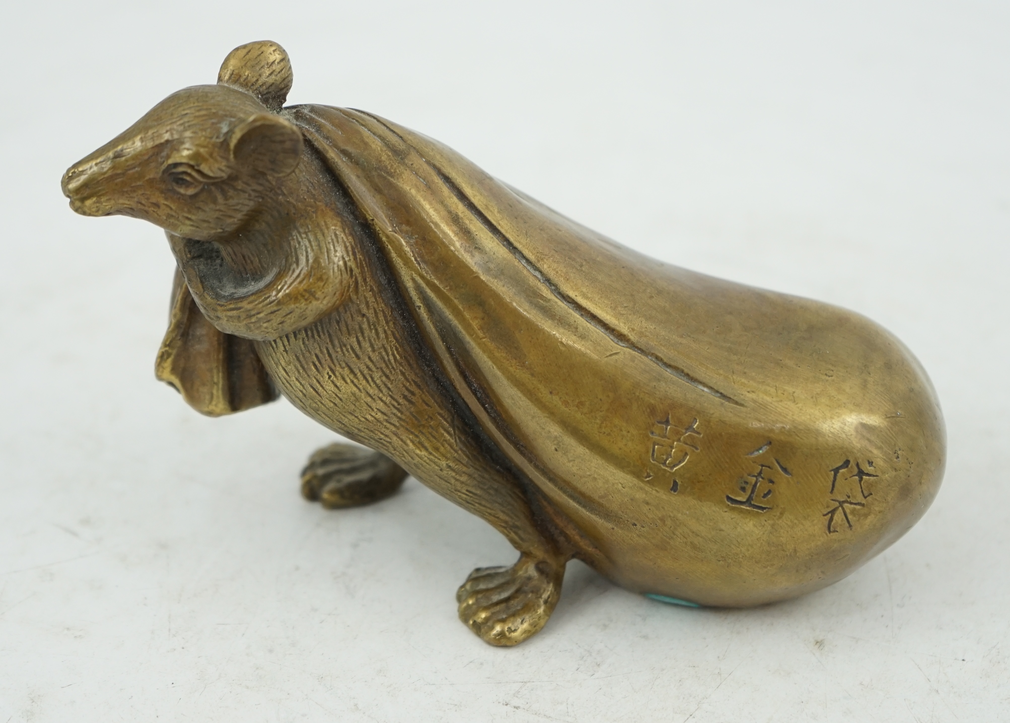 A Chinese bronze rat carrying a sack, signed in casting, 14cm long. Condition - fair